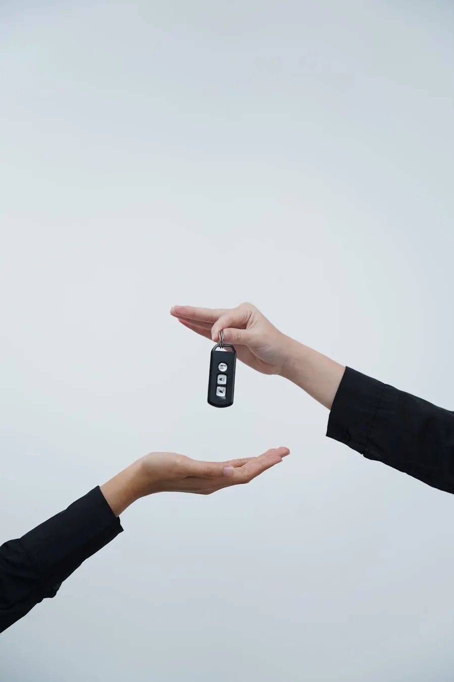 Two hands exchanging a car key