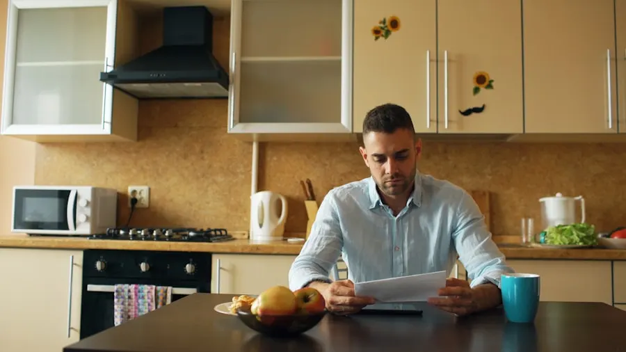 A man reading a document at his kitchen table over a cup of coffee